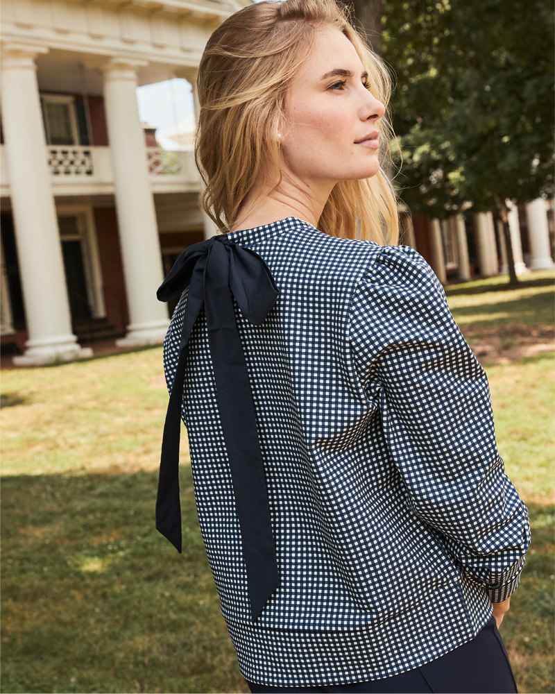 Model is wearing the beta bow pullover in navy gingham. 