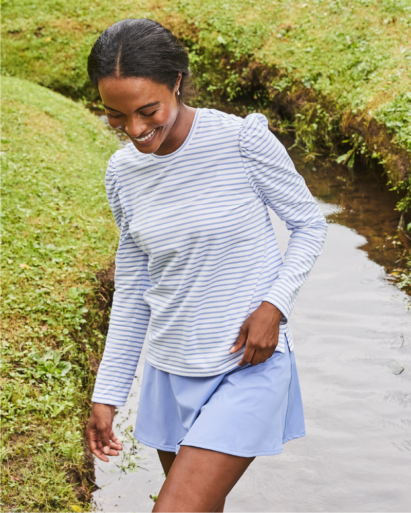Model is wearing the Fairmount Long Sleeve in Super White/ Violet Stripe with the Flounce Skort in Violet