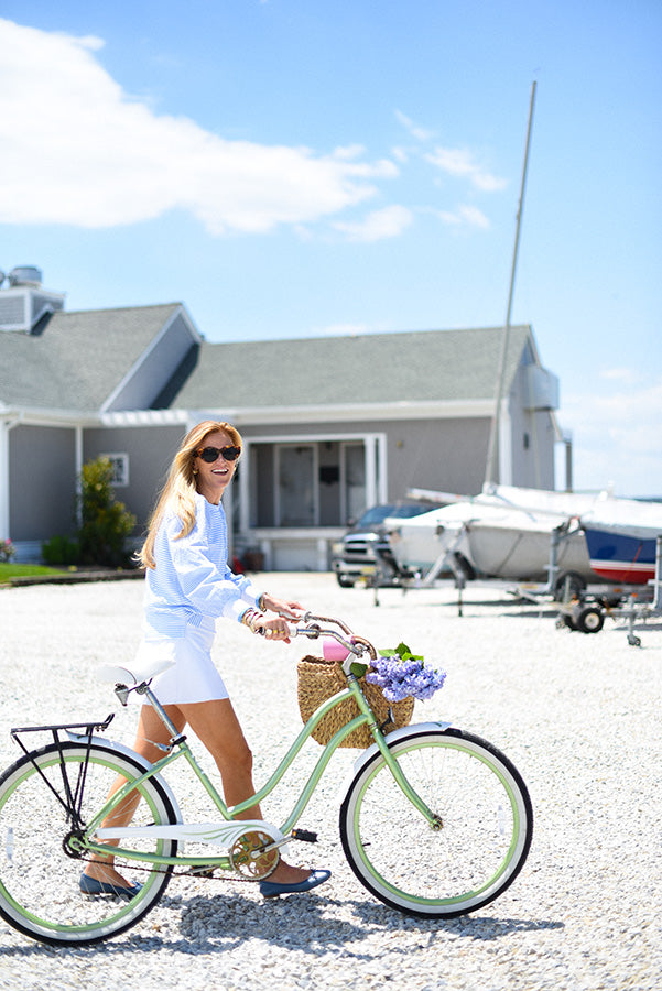 Marghi is wearing the Penny Pullover in Super White/Matisse Stripe and the Flounce Skort in Super White