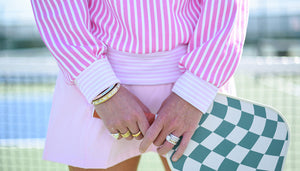 Marghi is wearing the Varsity Quarter Zip in Petal/Peony Stripe with the Flounce Skort in Petal