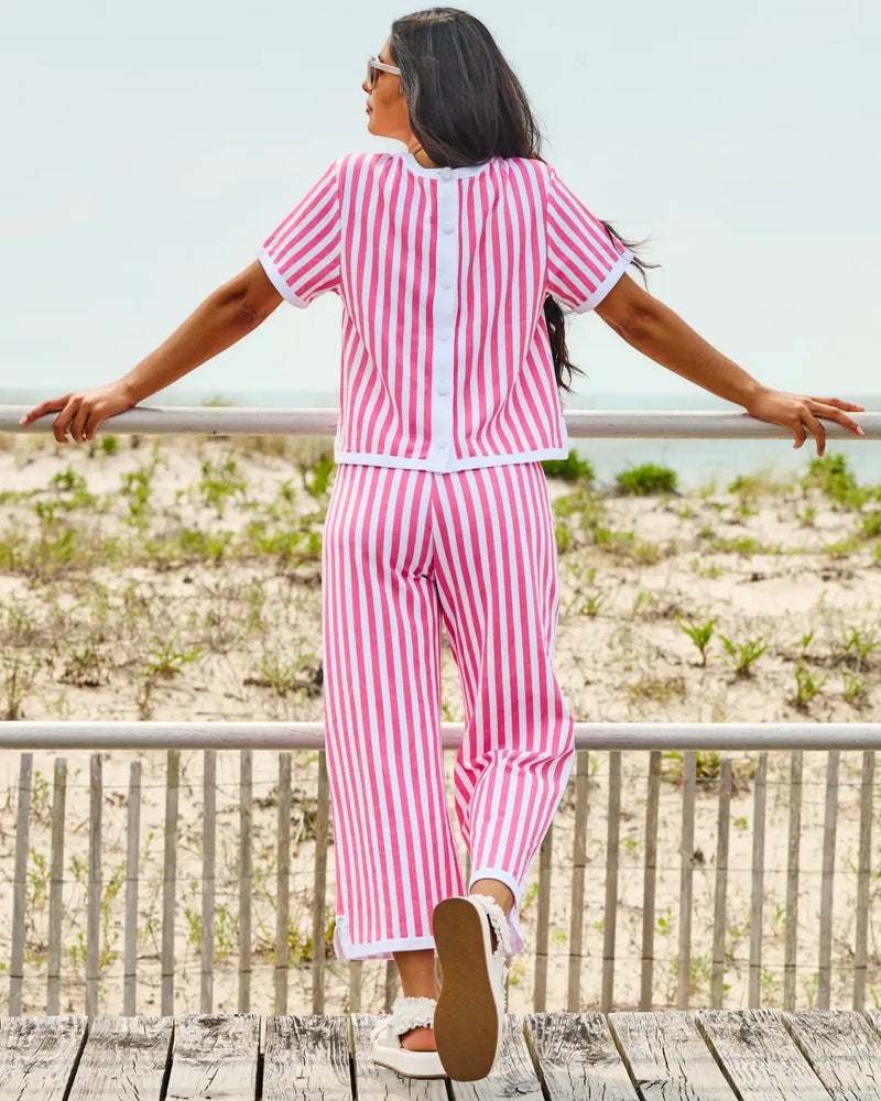 Model is wearing the textured pique Lennon short sleeve in guava cabana stripe paired with the lennon wide leg pants in guava cabana stripe.