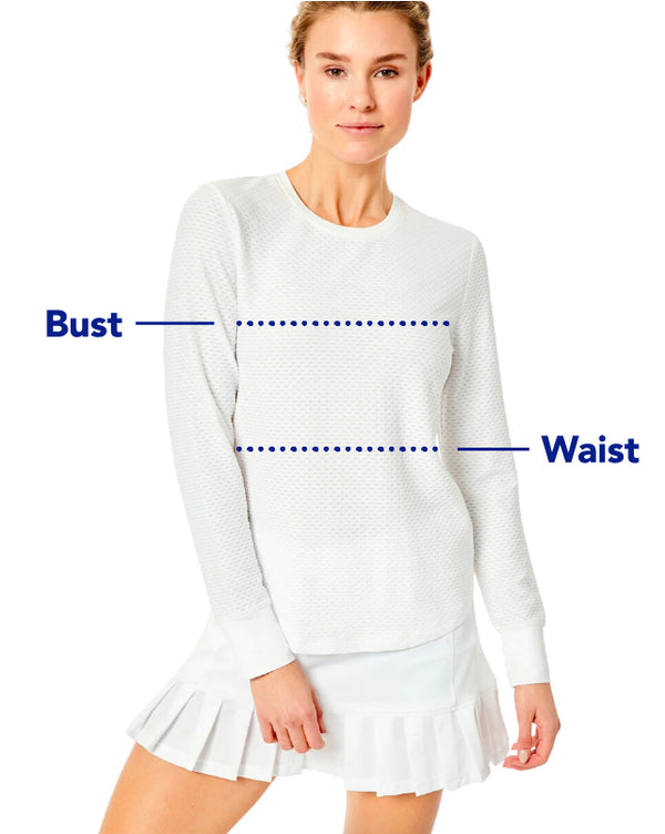 Model is wearing the Palmetto long sleeve in white with the court skort in White. Measurement points across the bust and waist.