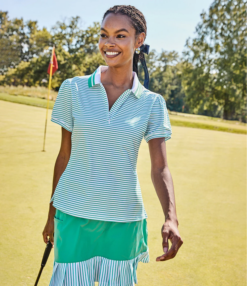 Model is wearing the Par Polo in Palm Stripe with the Birdie Golf Skort in Palm