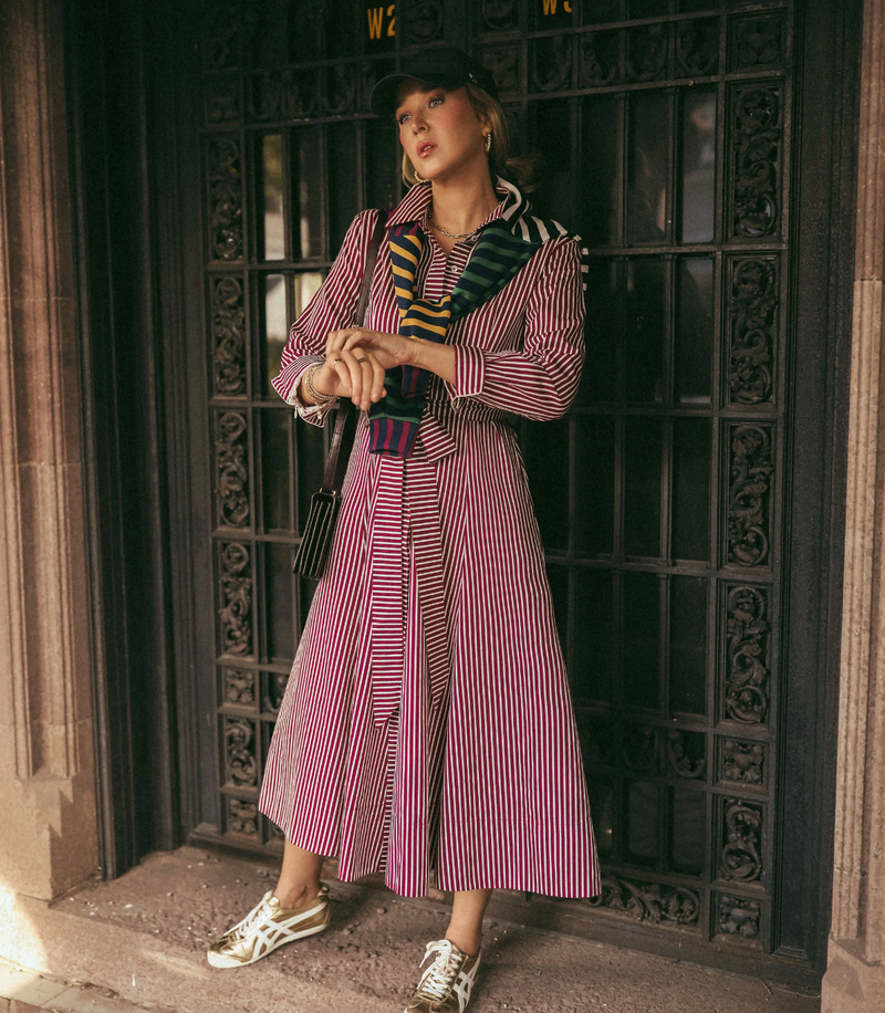 Mary Orton is wearing the Coco Dress x Addison Bay in Burgundy/Off White Stripe with the Varsity Quarter Zip in Mary Multi tied around her shoulders