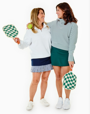 Models from the 6th birthday photo shoot. Model left is wearing the Court Skort in Navy Blue/Stripe with the Varsity Quarter Zip in Super White. Model Right is wearing the Everyother Day Pullover in Super White/Ivy Stripe with the Everyday Skort in Ivy