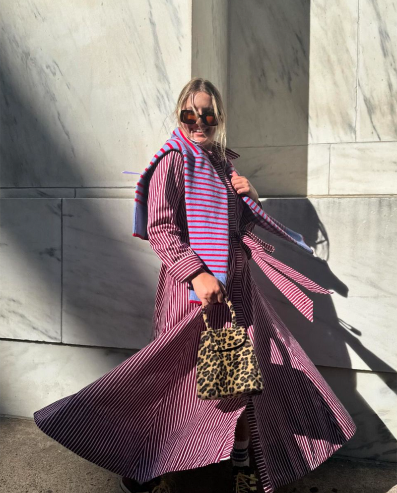 Olivia is wearing the Coco Drees x Mary Orton in Burgundy/Ivory with the Carlyle Sweater in Violet/Cherry Stripe over her shoulders