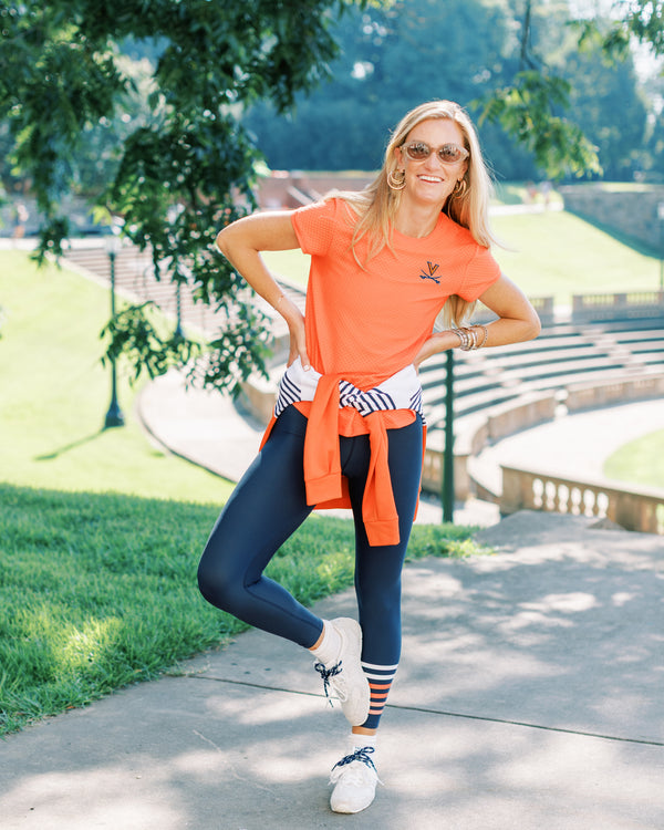 'On model product image of Collegiate Active Mesh Palmetto Short Sleeve in UVA Papaya'