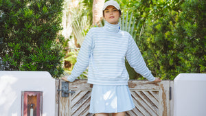 Model is wearing the Lyndon Pullover in Baby Blue/Super White Stripe with the Flounce Skort in Baby Blue