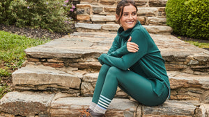 Model is wearing the Rittenhouse Pullover in Ivy with the Everyday Legging in Ivy/Violet Stripe