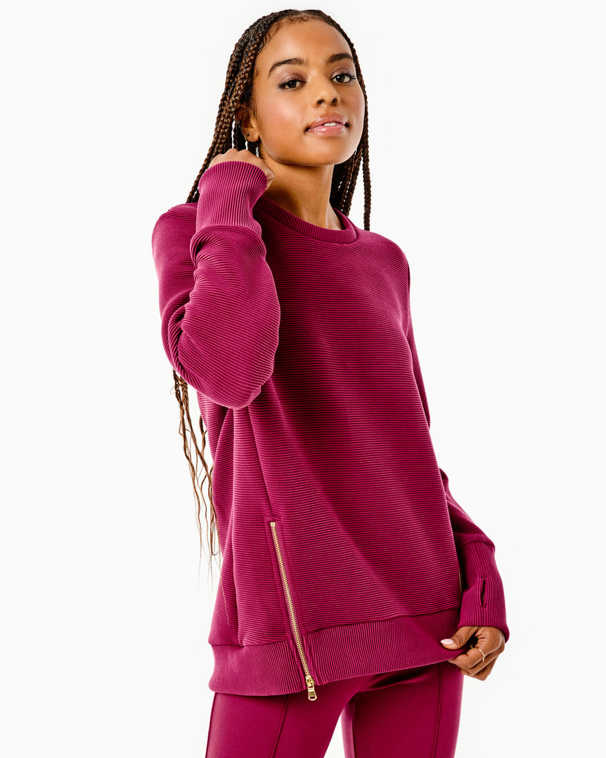 Model is wearing the everyday crewneck. This style features a pull on style, ribbed fabrication with zipper details on body and thumb holes at sleeve cuff. This is in solid black and paired back with the everyday active legging in black.