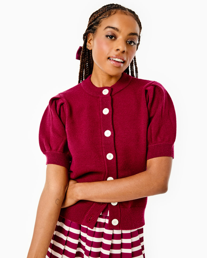 Model is wearing the Gigi Cardigan x Mary Orton in Burgundy with the Liza Skirt x Mary Orton Burgundy/ Ivory Stripe and the Charlotte Bow x Mary Orton in Burgundy in her hair