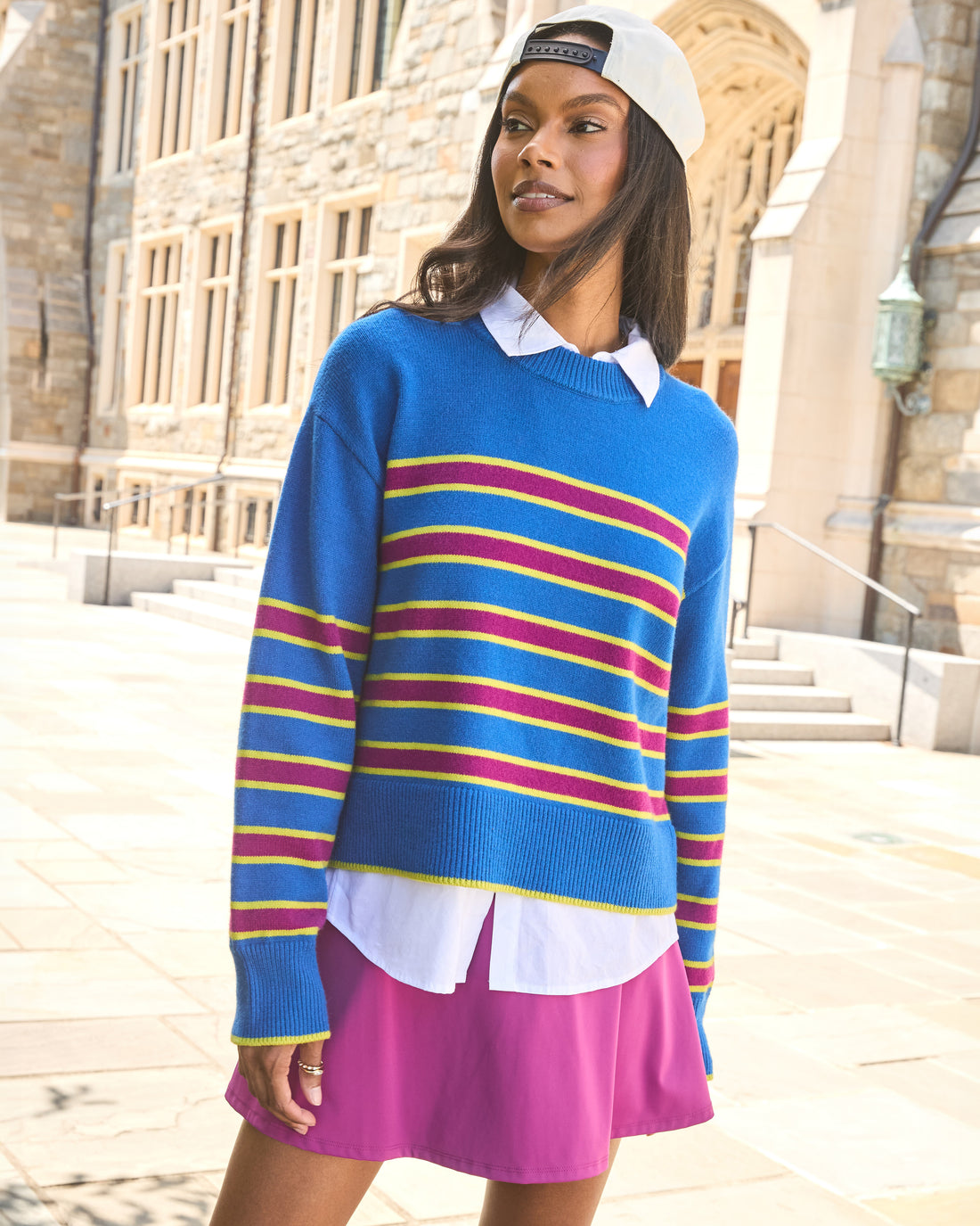 Model is wearing the junior carlyle crewneck sweater in lavender/violet stripe paired with the baseline skort in violet