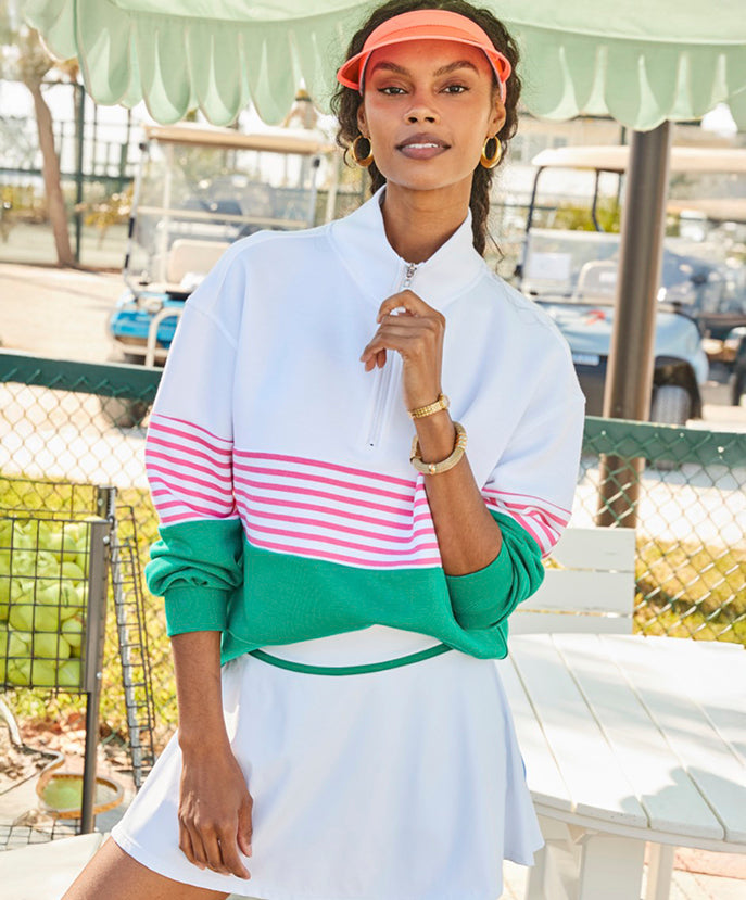 Model is wearing the JV Quarter Zip in Super White/Guava/Greenbrier with the Seamed Flounce Skort in Super White/Spring Multi