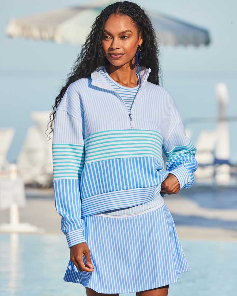 Model is wearing the JV Quarter Zip in Tonal Blue Multi over the Fairmount Long Sleeve in Super White/ Matisse Stripe with the Seamed Flounce Skort in Tonal Blue Multi