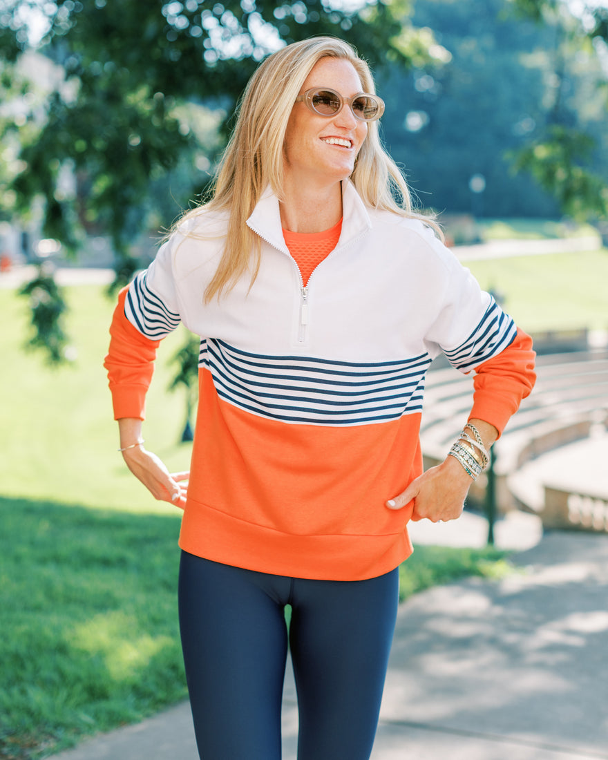 the model is wearing varsity quarter zip in petal multi stripe with the everyday skort in petal/ peony stripe