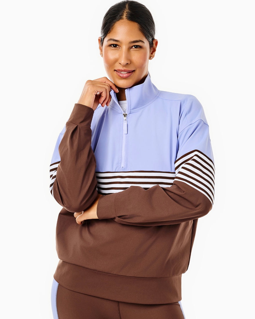 the model is wearing varsity quarter zip in petal multi stripe with the everyday skort in petal/ peony stripe