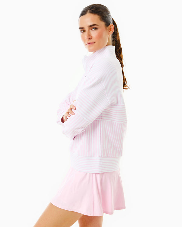 Model is wearing the Varsity Quarter Zip in White/Petal Stripe over the Walnut Short Sleeve in Petal with the Flounce Skort in Petal