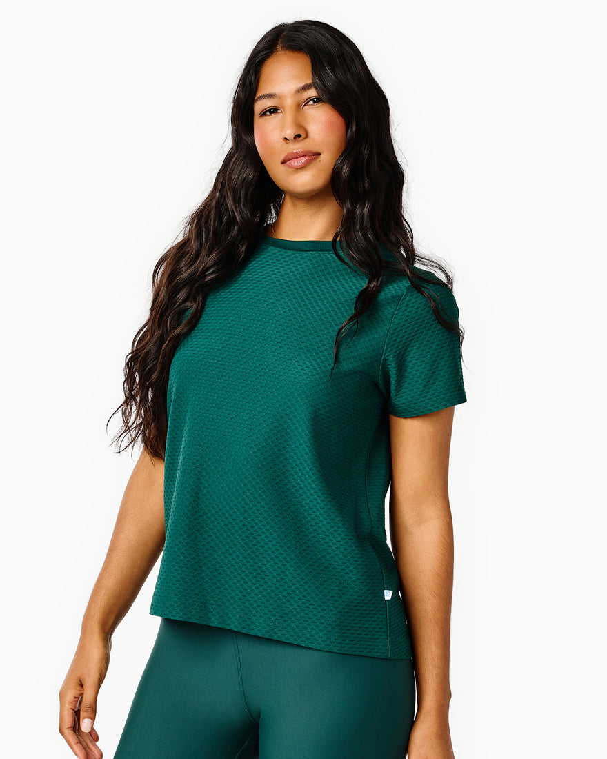 Model is wearing the Walnut Short Sleeve in white with the Everyday Skort in white. 