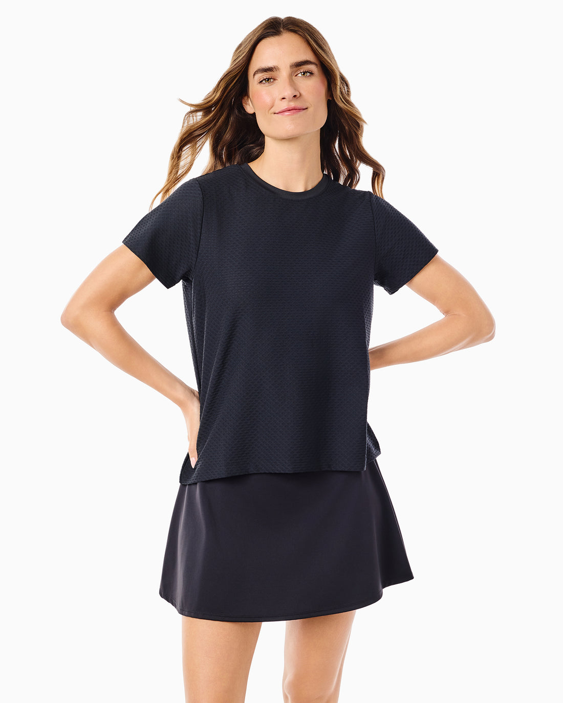 Model is wearing the Walnut Short Sleeve in white with the Everyday Skort in white. 